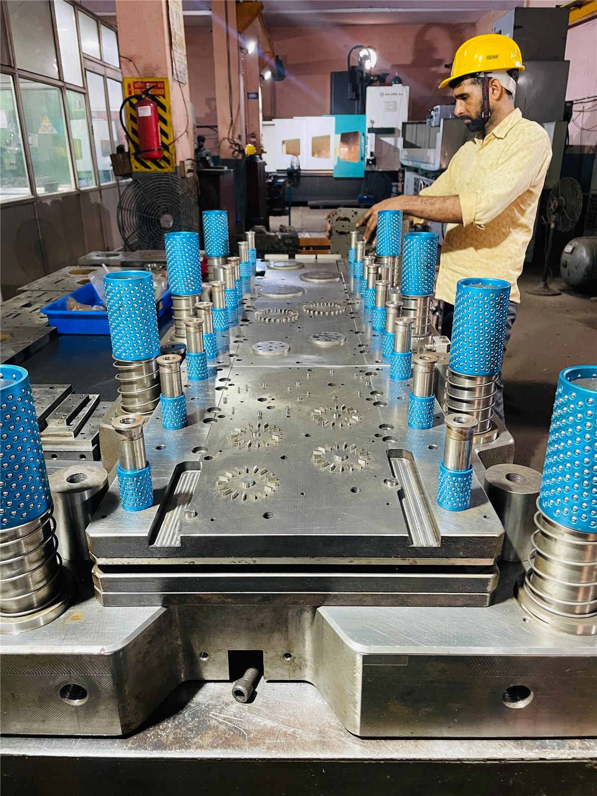SPTI engineer inspecting a multi-row lamination progressive die with blue ball-cage guide posts