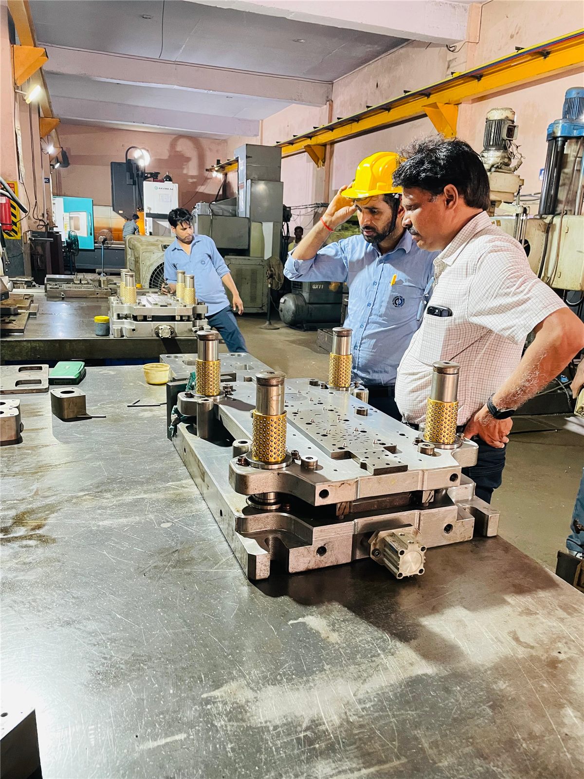 SPTI engineers inspecting a progressive die on the shop floor